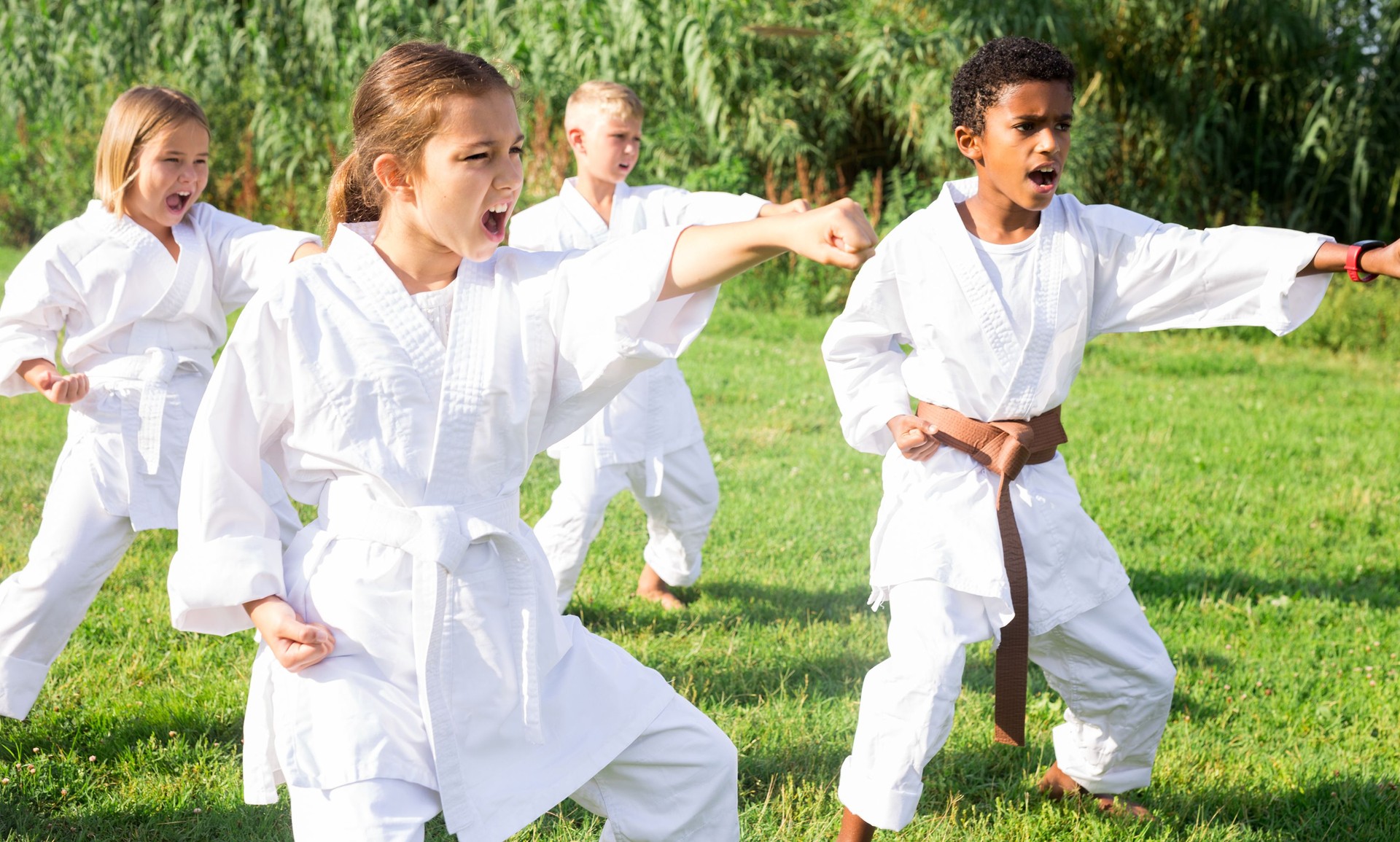 Positive children practicing karate in park